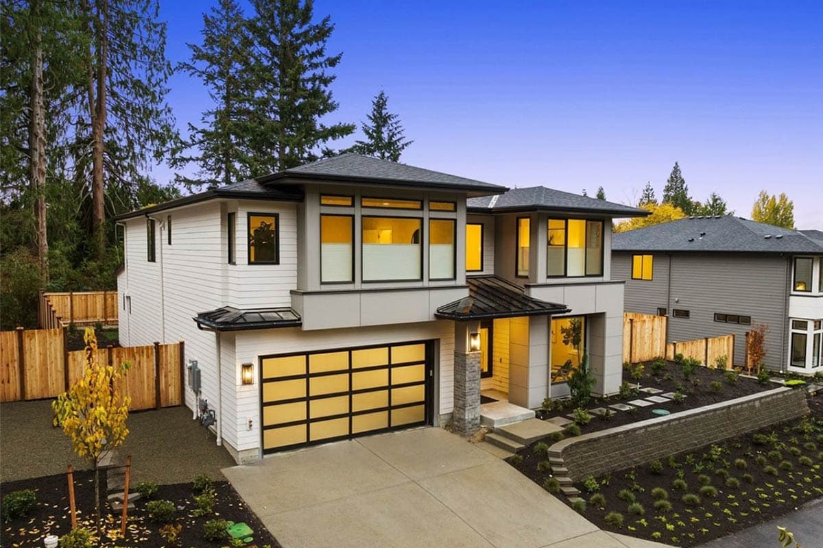Modern two-story house plan exterior with a prominent garage, large windows, and a covered entry.