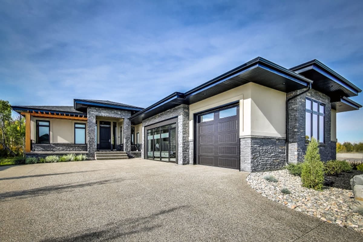 House plan exterior with modern design. Features include flat rooflines, stone veneer accents, an attached garage, and a covered entry porch.