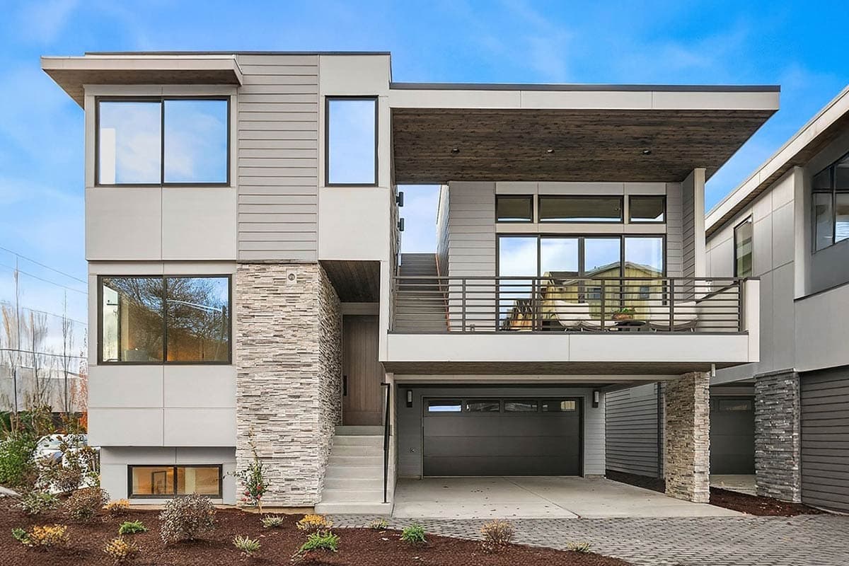 House plan exterior: Modern two-story home with a flat roof. Features include an integrated garage, stone veneer accent, and a cantilevered balcony.