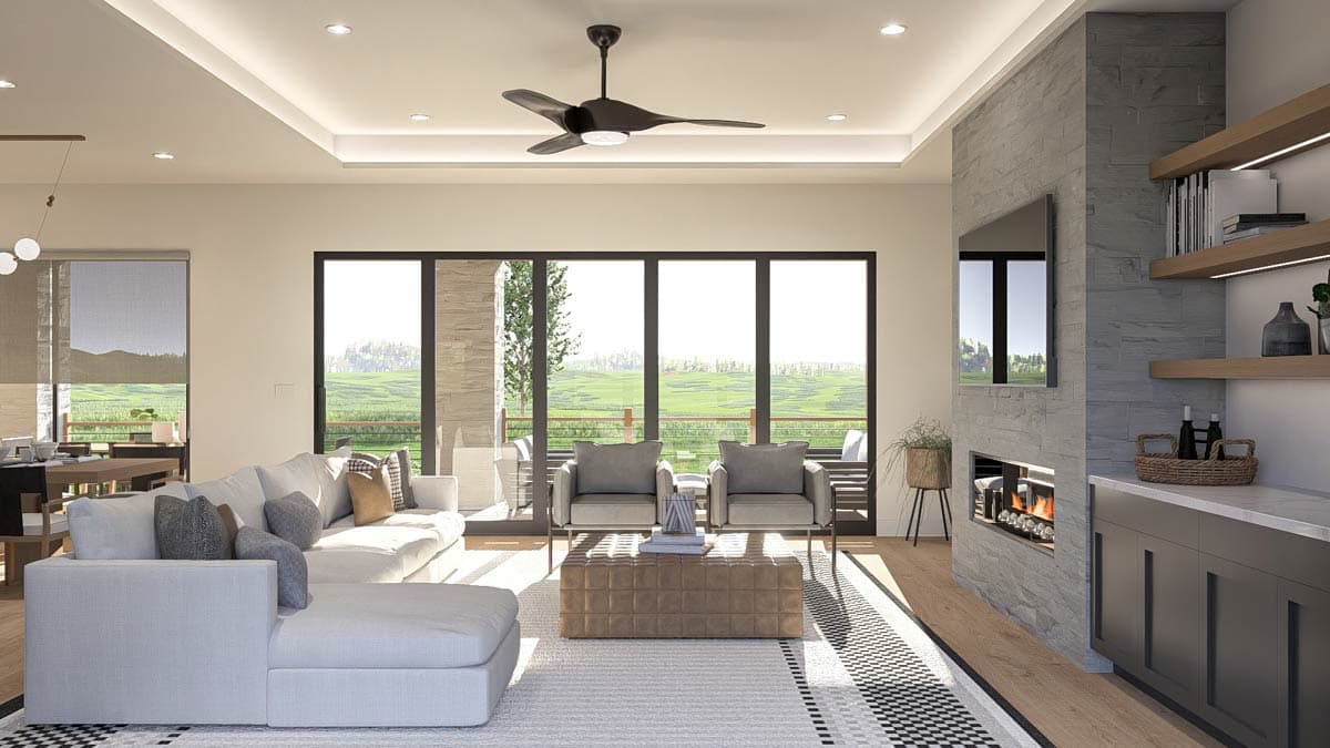 Contemporary living room with sectional sofa, fireplace, built-in shelving, and large sliding glass doors opening to an outdoor view.