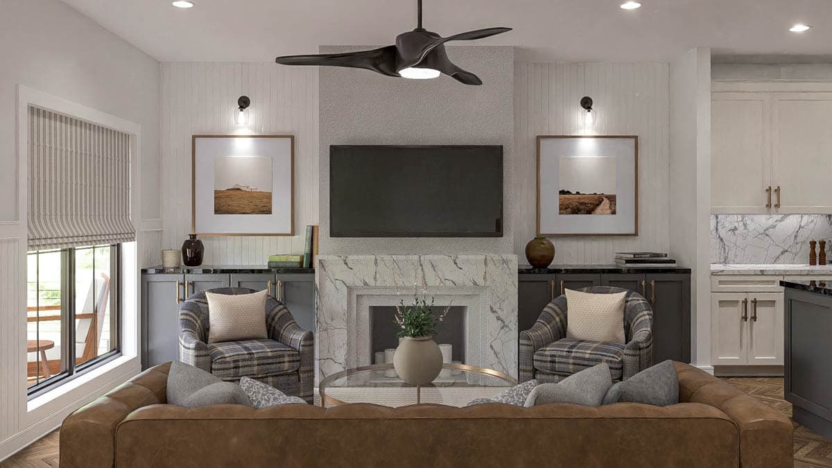 Living room interior with fireplace, mounted TV, seating, window, and adjacent kitchen cabinetry.