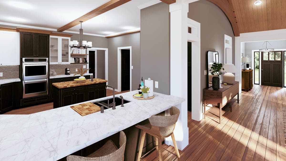 Open-concept kitchen featuring a large island with seating, double ovens, and decorative ceiling beams.