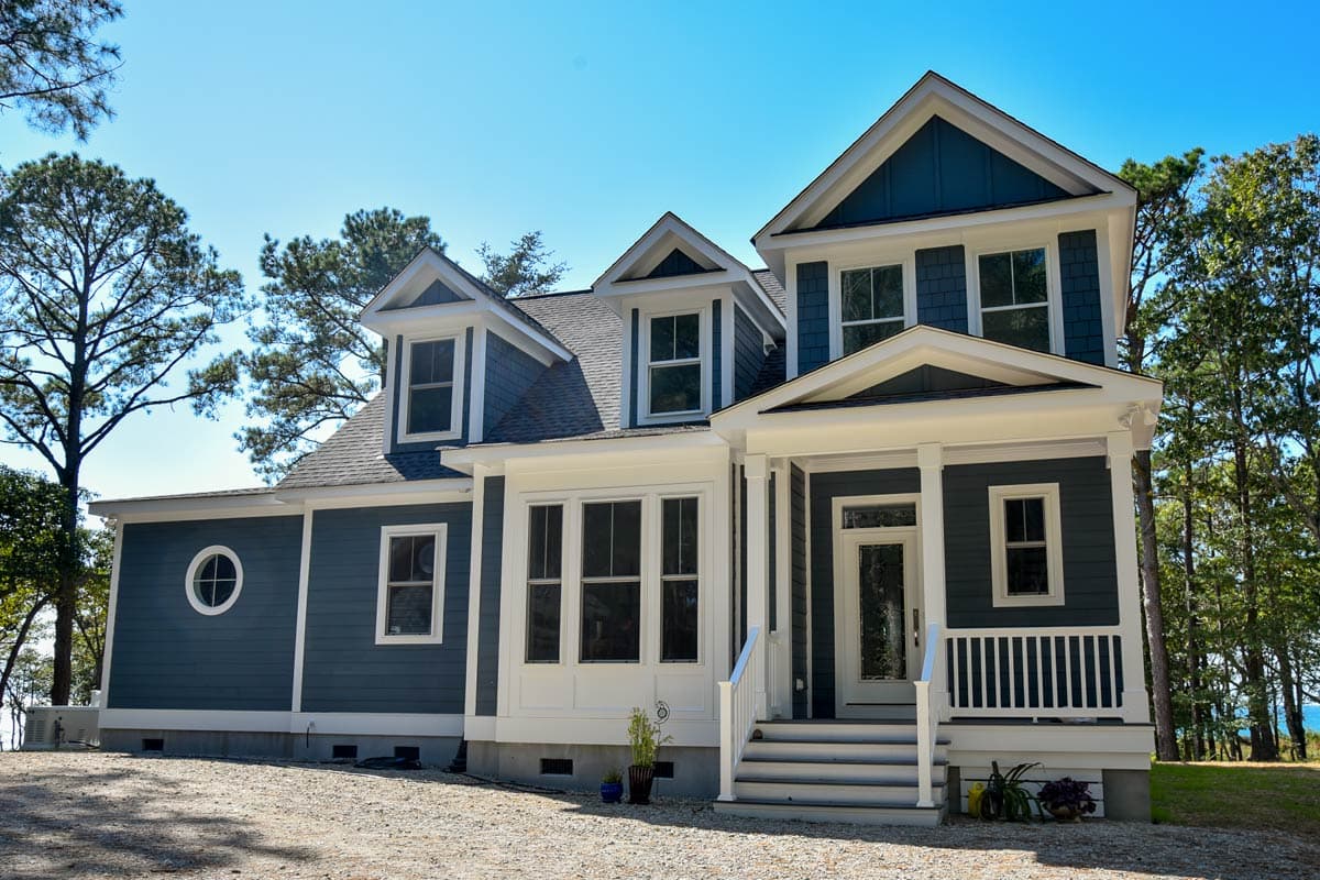 House plan exterior. Two-story Craftsman home with a front porch, gabled roof, and multiple dormers.