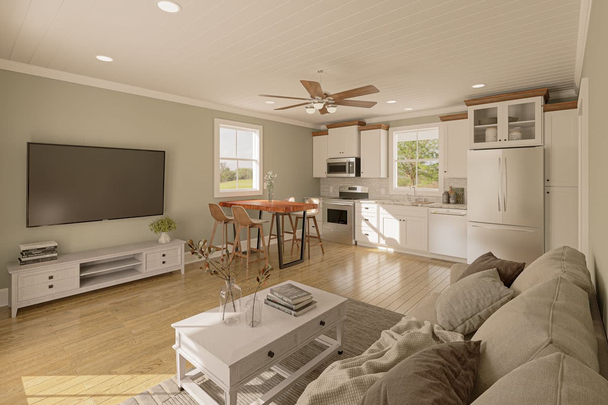Open concept living area with kitchen featuring white cabinetry, stainless steel appliances, and breakfast bar.