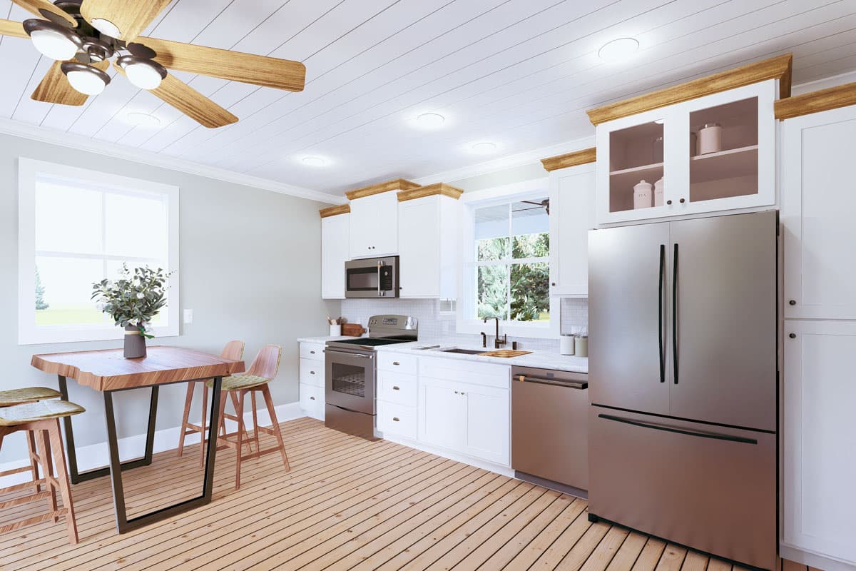 Kitchen interior with white cabinets, stainless steel appliances, wood dining table with stools, and a wood plank ceiling with fan.