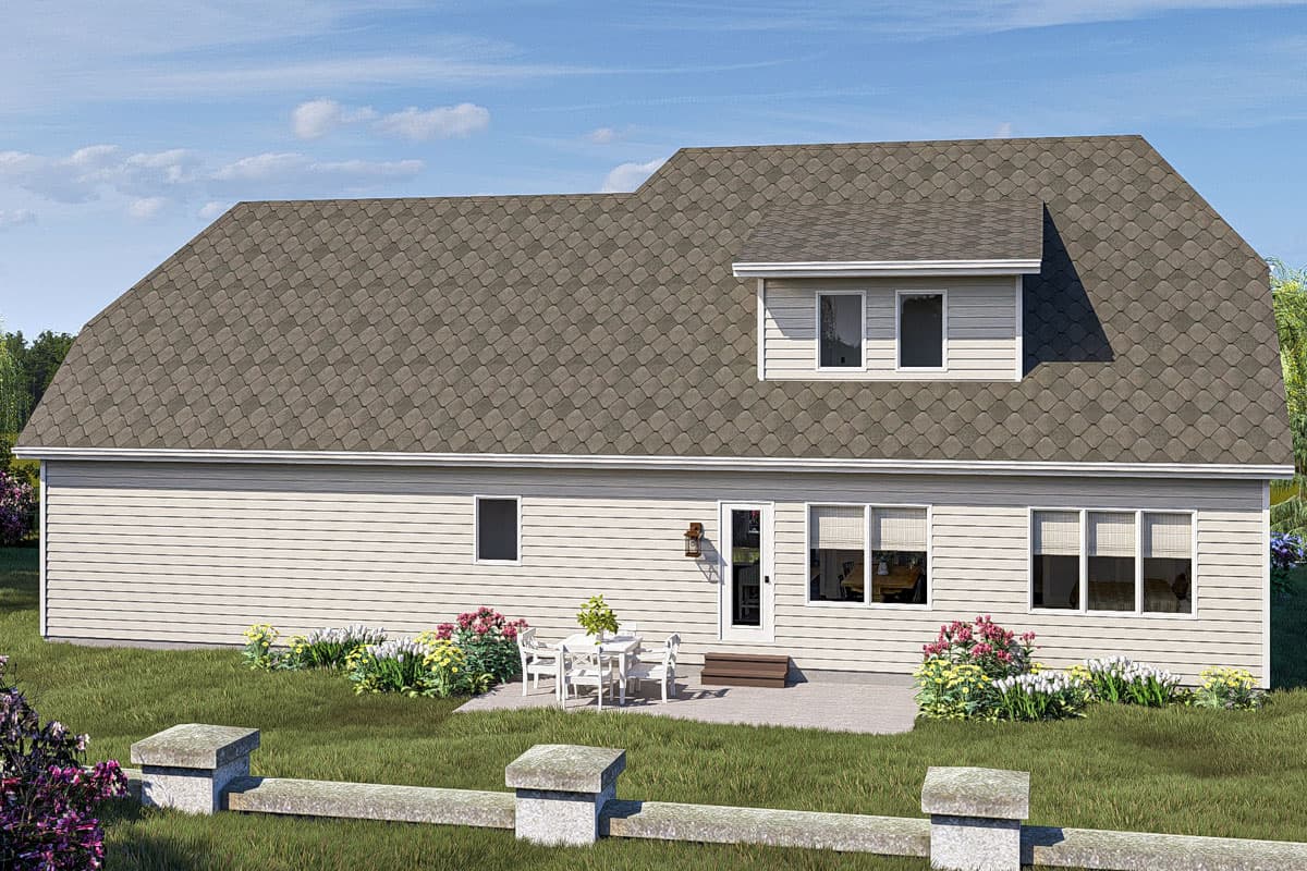 House plan exterior: Two-story home with a dormer, gray shingled roof, white siding, and a patio with outdoor seating.