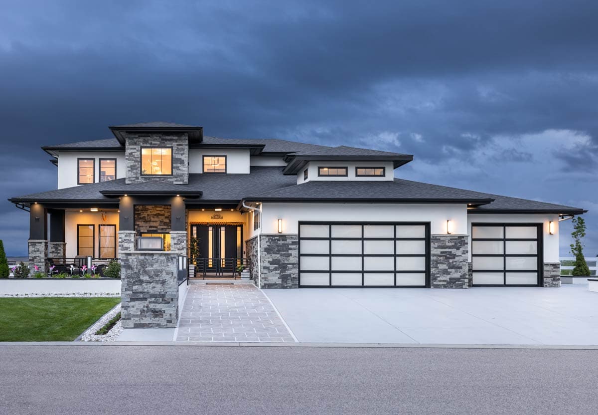 House plan exterior. Modern style with two stories, stone accents, glass garage doors, and a covered entry porch.