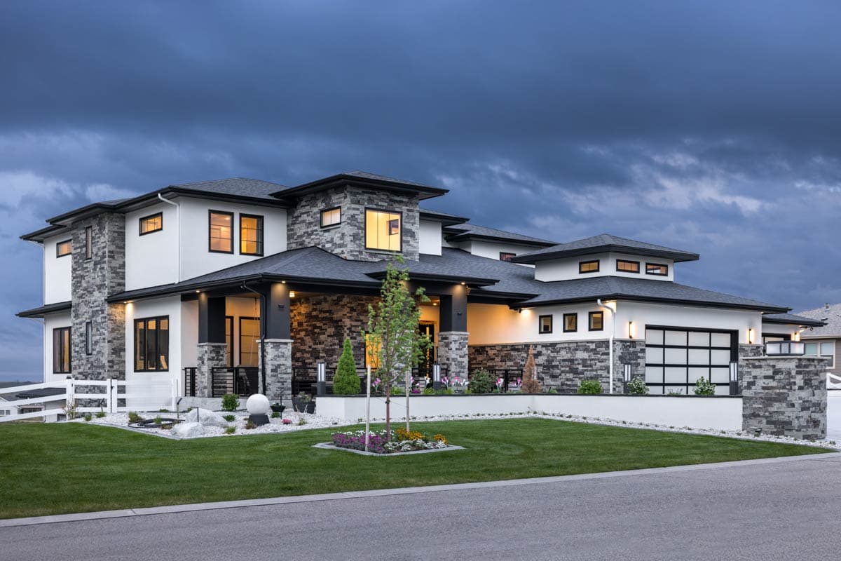 House plan exterior: Modern style, two-story home with stone accents, covered entry, multiple gables, and a contemporary garage door.