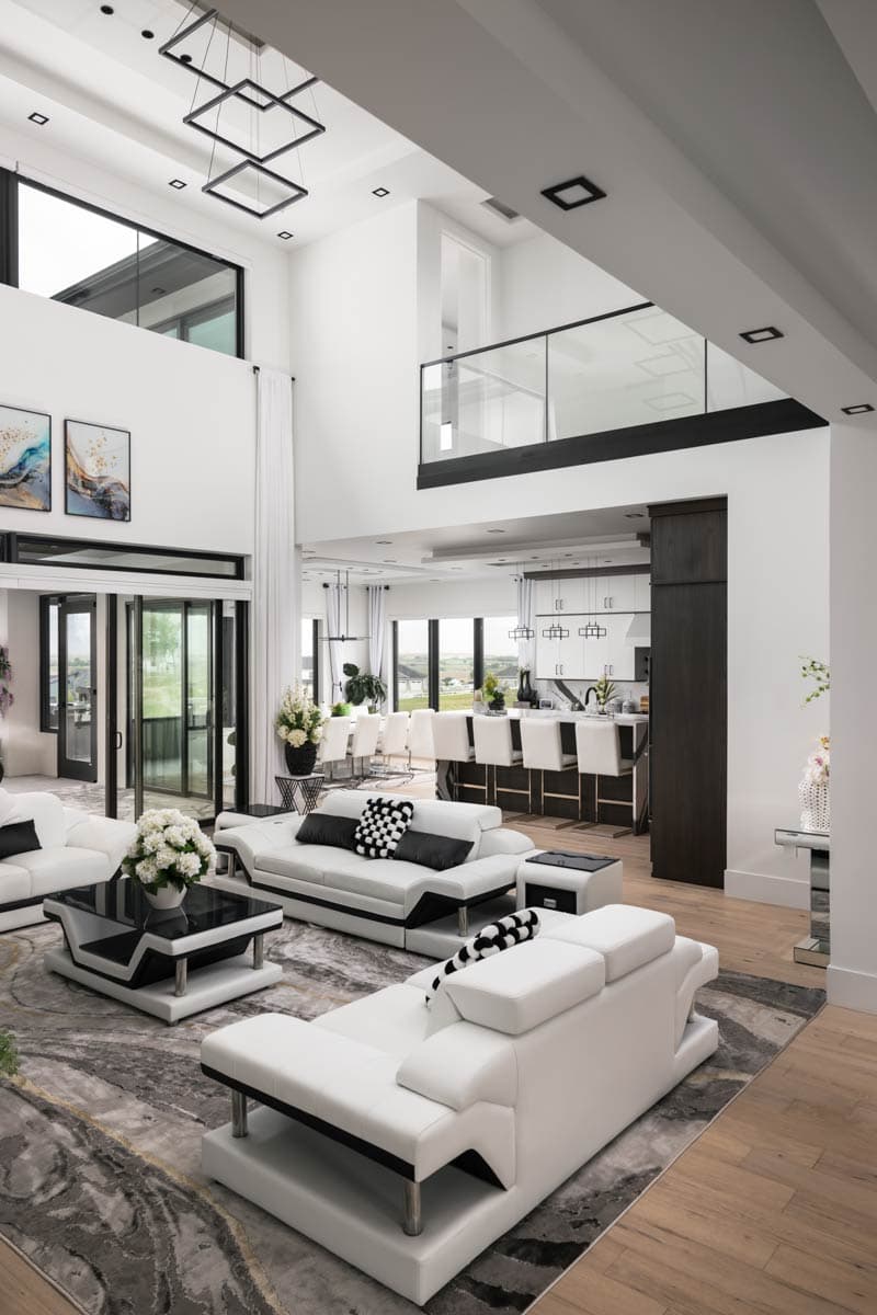 Open-concept living area with a sunken living room, kitchen island with bar seating, and a second-story glass balcony.