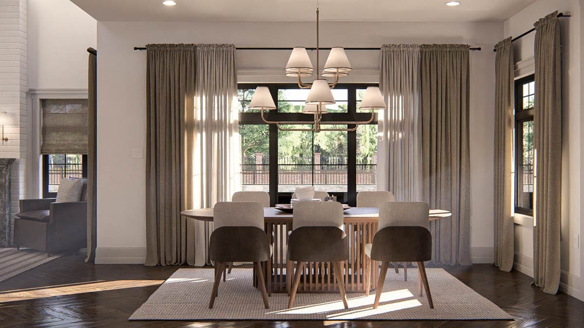 Dining room with oval table, six chairs, modern chandelier, and large windows with drapes.