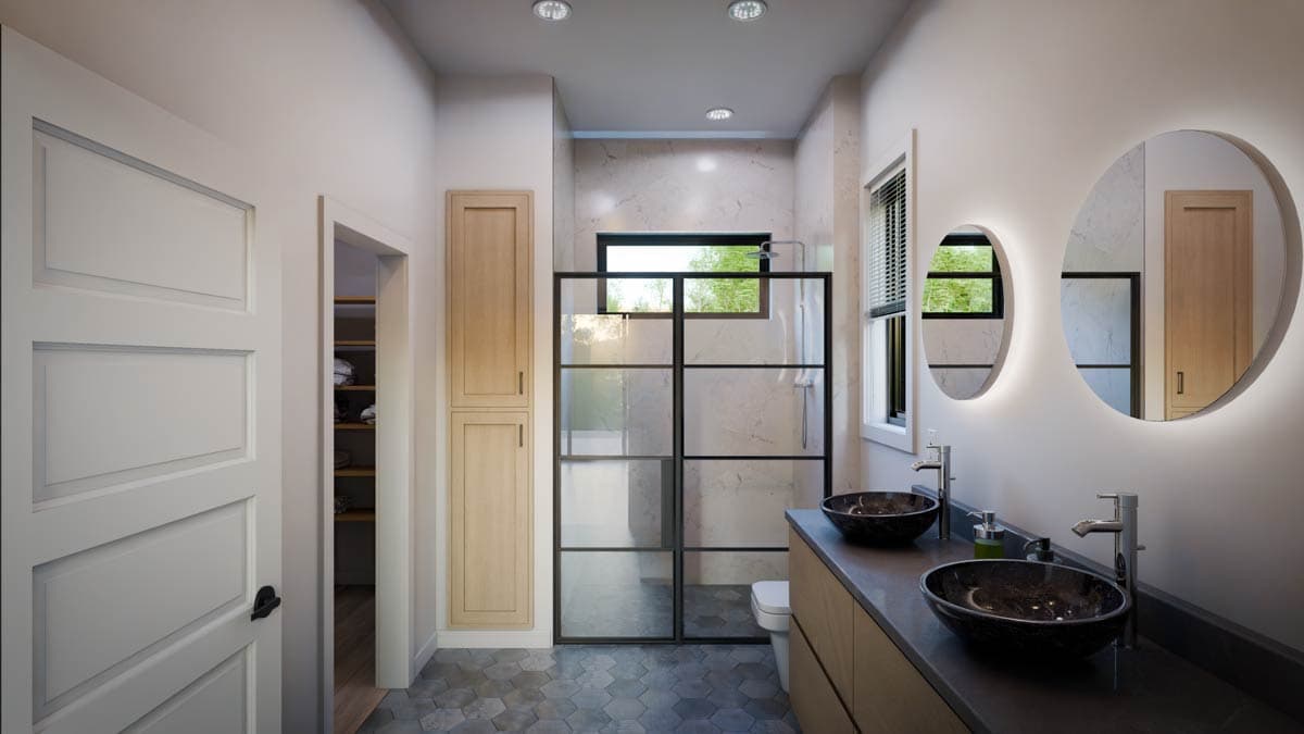 Bathroom interior with double vanity, vessel sinks, glass-enclosed shower, and tall linen cabinet.