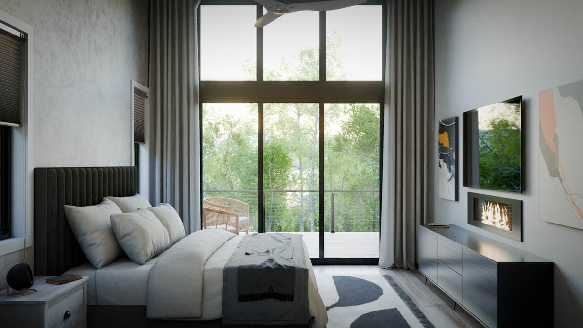 Modern bedroom with king bed, fireplace, large windows, and balcony overlooking forest.