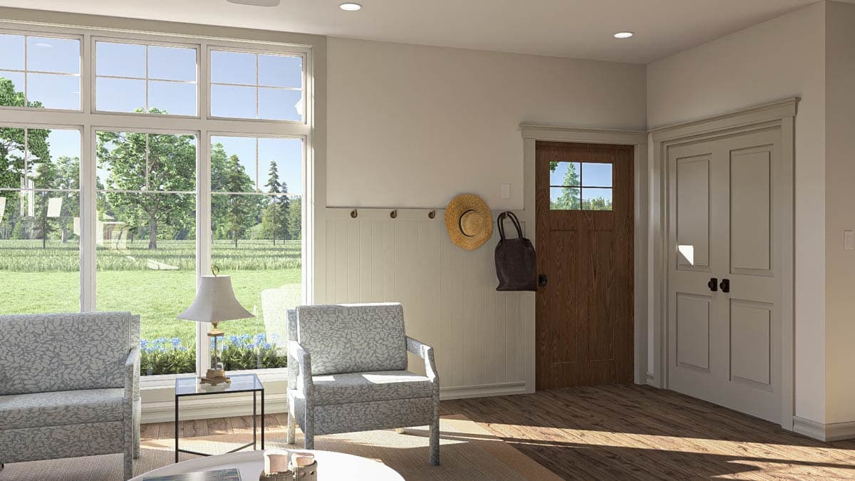 Interior view showing a sunlit room with large windows, paneled wainscoting, and two interior doors.