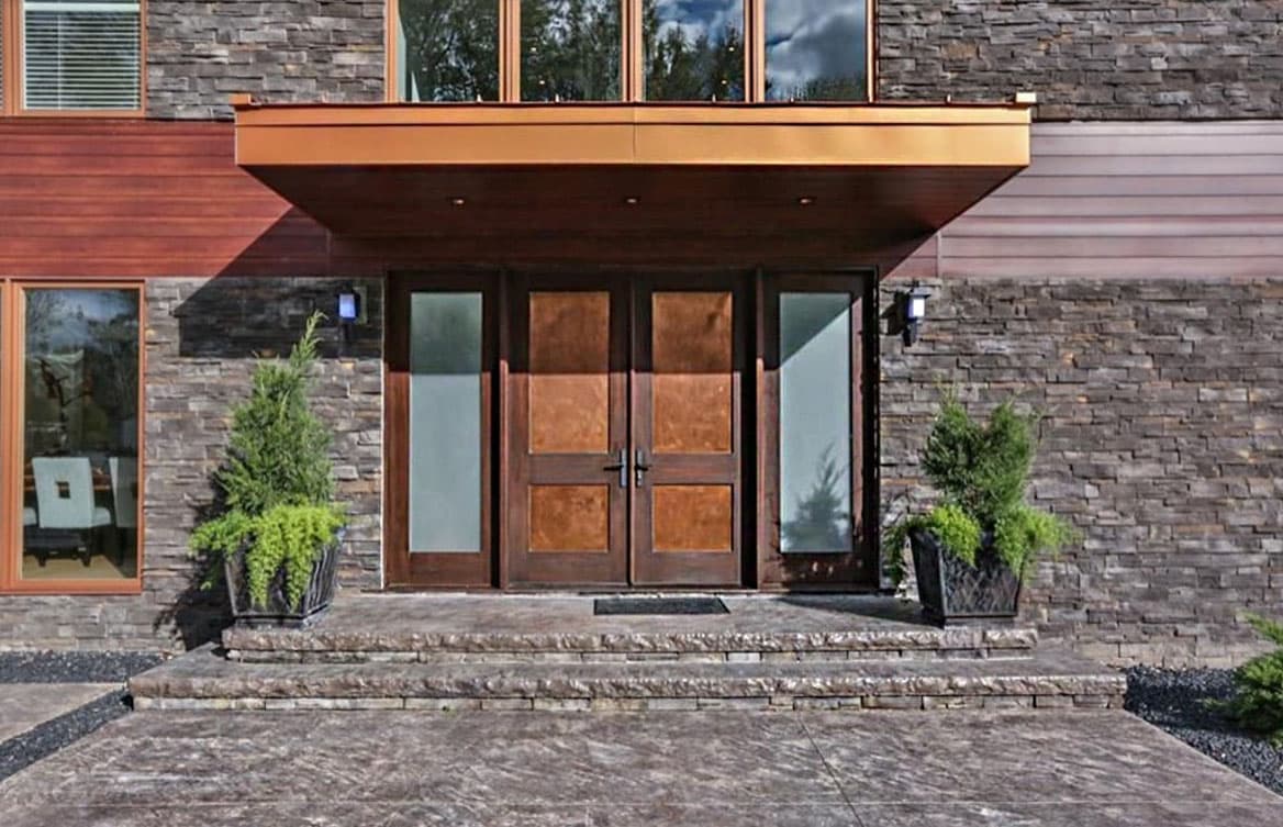 House plan exterior featuring stacked stone, wood siding, and a dual wooden door entry with sidelights.