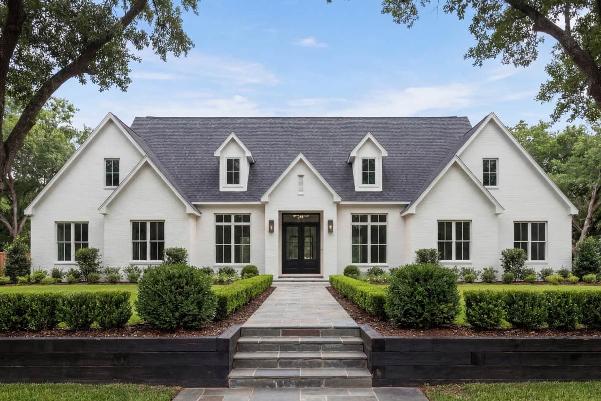Modern Farmhouse house plan exterior with white brick, gables, dormers, and double entry doors.