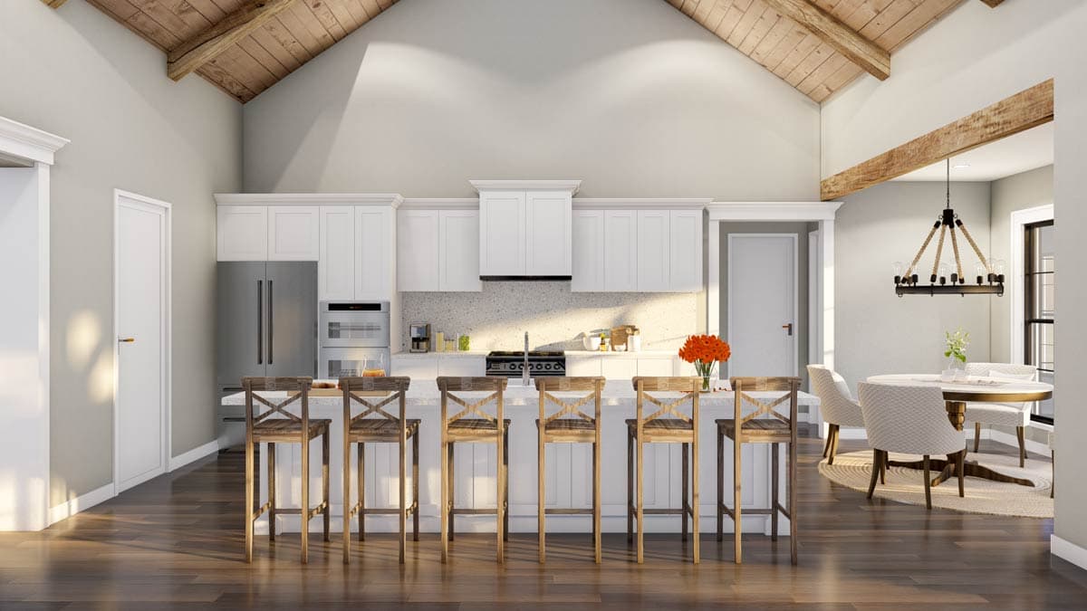 Kitchen with vaulted ceiling, exposed beams, white cabinets, island with seating, and stainless steel appliances.