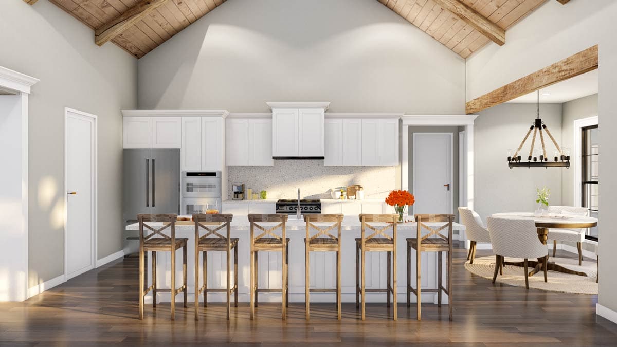 Kitchen with vaulted ceiling, wood beams, island with bar stools, and adjacent dining area.