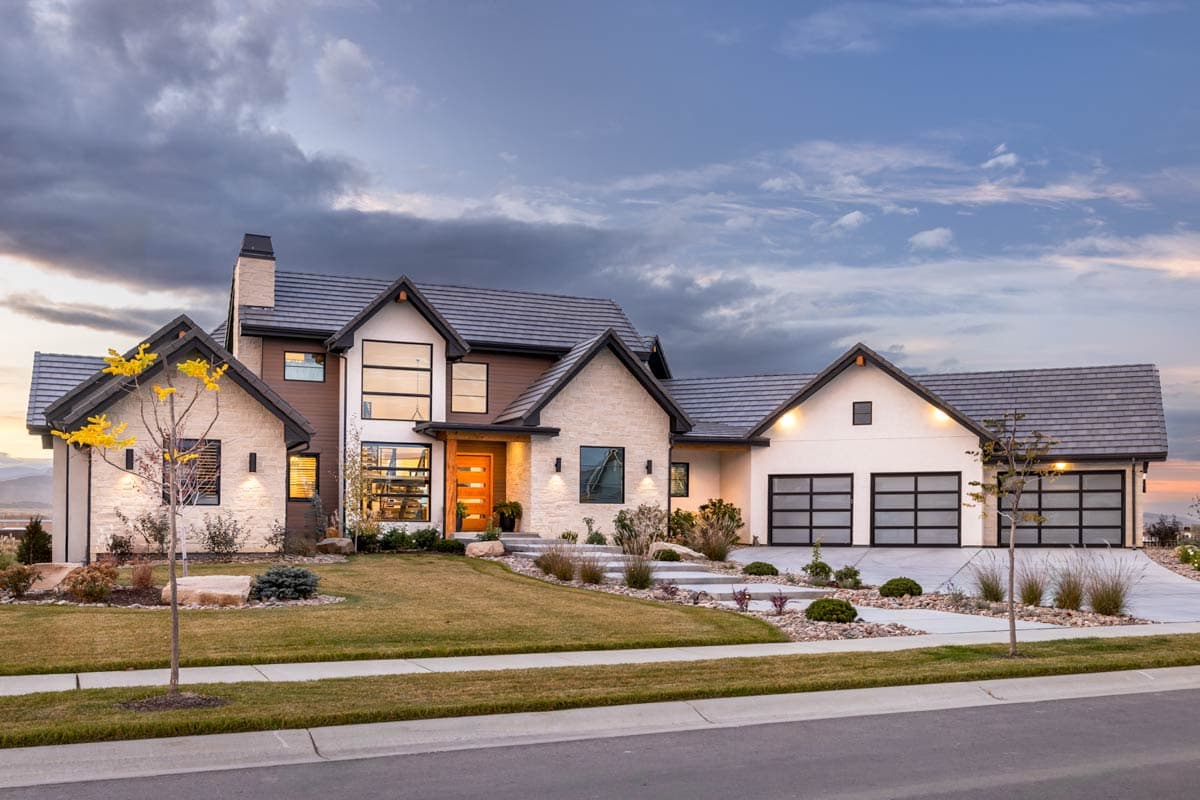 Modern house plan exterior with stone accents, wood entryway, large windows, and a three-car garage.