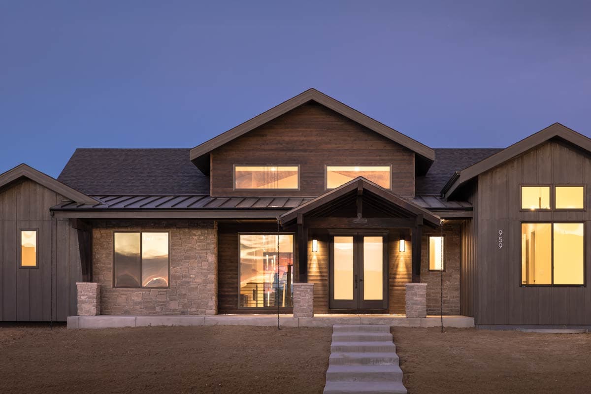 House plan exterior featuring stone and wood siding, a prominent gable, and a covered entry with double doors.
