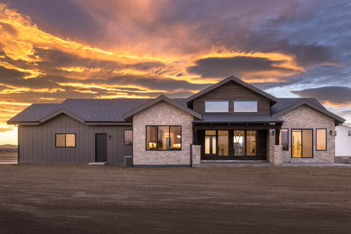 Modern house plan exterior with stone and wood siding, gables, and a covered entrance.