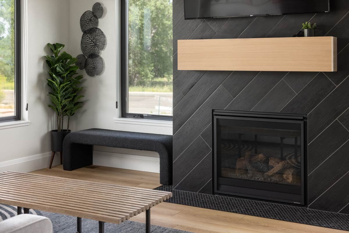 Interior view of a living room with a fireplace, light wood shelf, and modern bench.