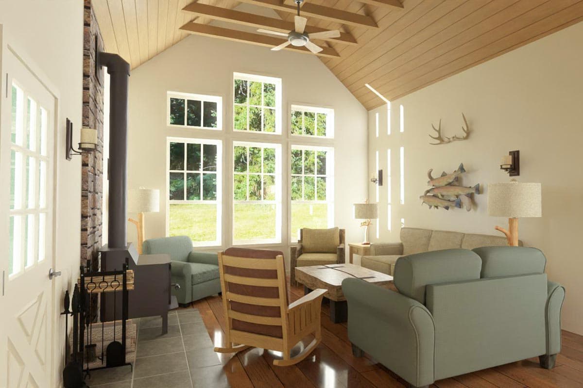 Living room with a high ceiling, large windows, wood stove, and a mix of chairs and a sofa. Decorations include antlers and fish.
