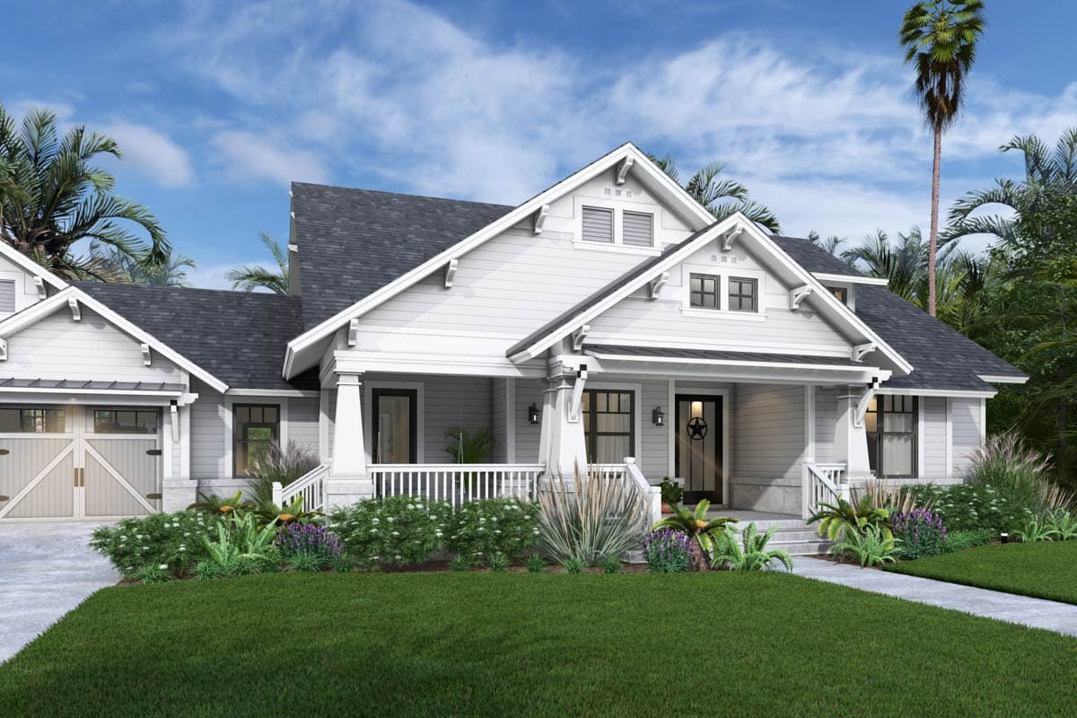 A two-story, white house with a porch and dark gray roof. Landscaping includes green lawn, bushes, and palm trees against a blue sky.