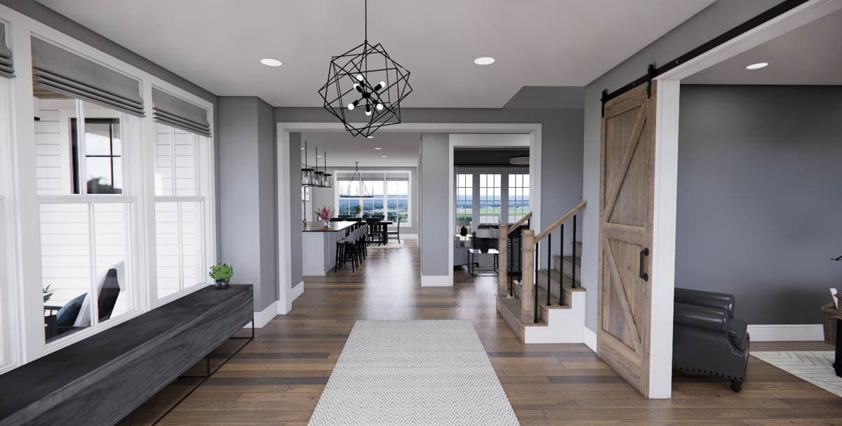 Interior rendering of house plan with view into kitchen, dining, and living areas. Features barn door, stairs, and modern chandelier.