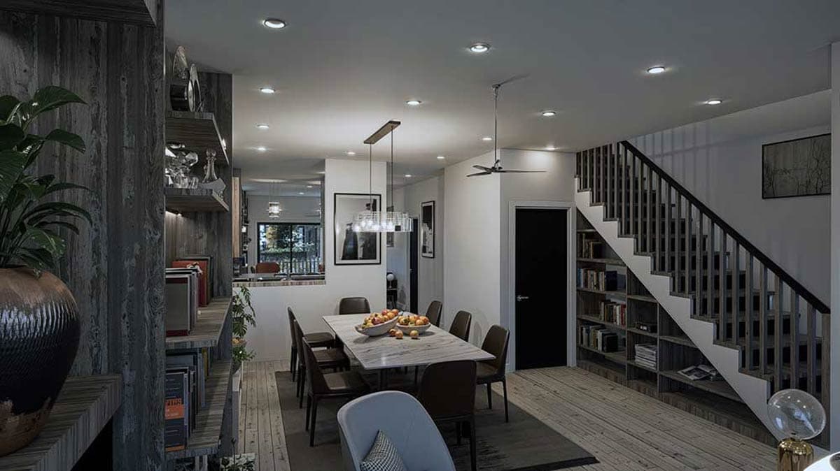 Dining area with marble-top table and chairs, adjacent to staircase with built-in bookshelves.
