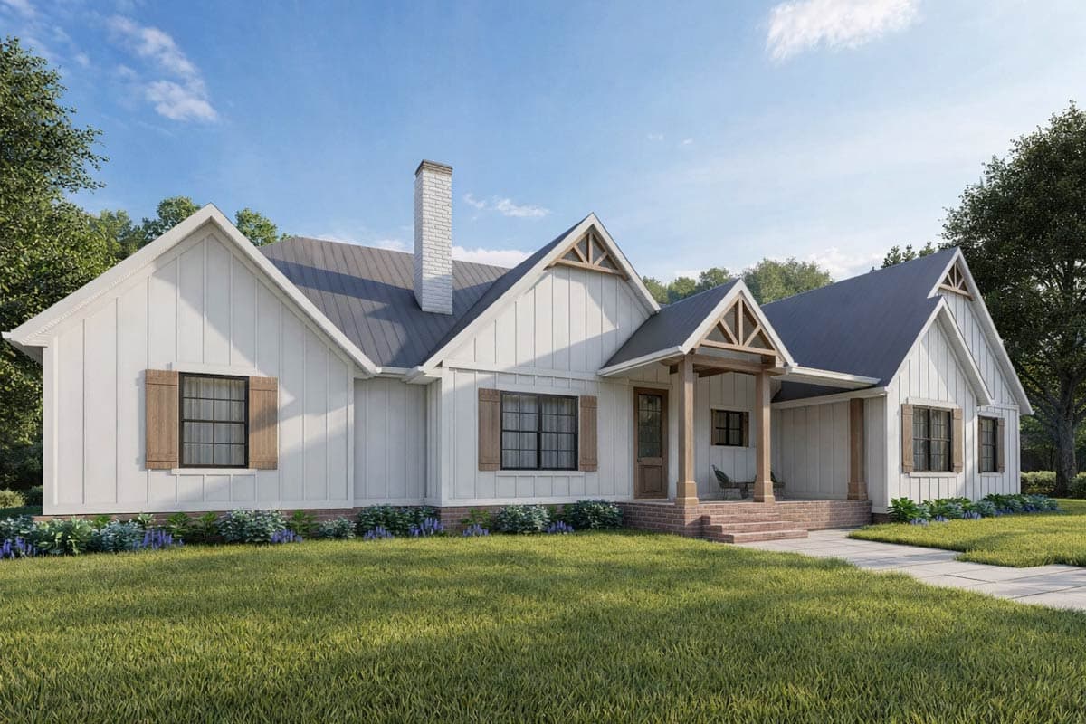A white farmhouse with a gabled roof, wooden shutters, and a brick porch. Lush green grass and blue skies provide a bright, natural backdrop.