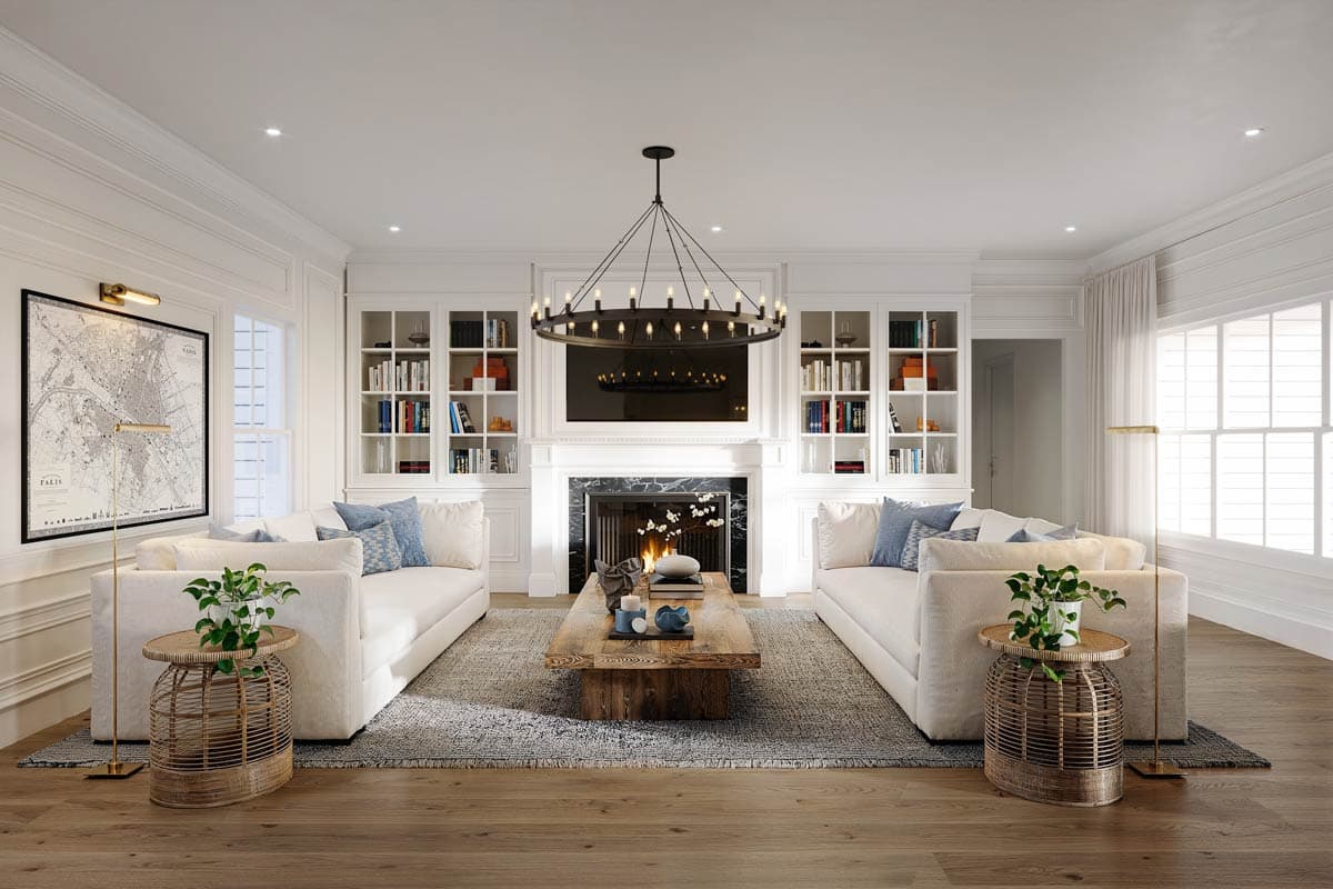 Spacious, bright living room featuring two white sofas facing a fireplace and TV. A large chandelier hangs overhead, with bookshelves on either side.