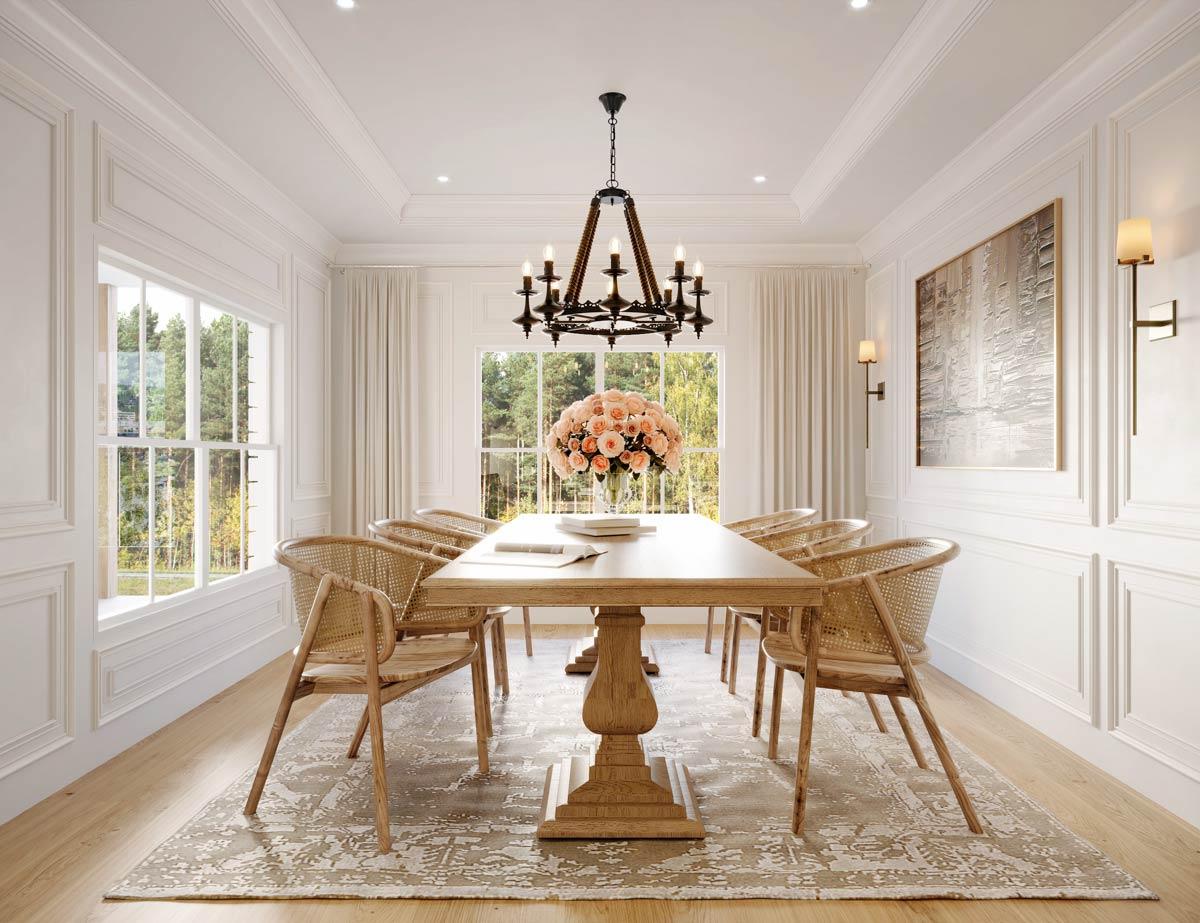 Elegant dining room with a long wooden table, six rattan chairs, and a floral centerpiece. A chandelier hangs above, with a view of trees outside.