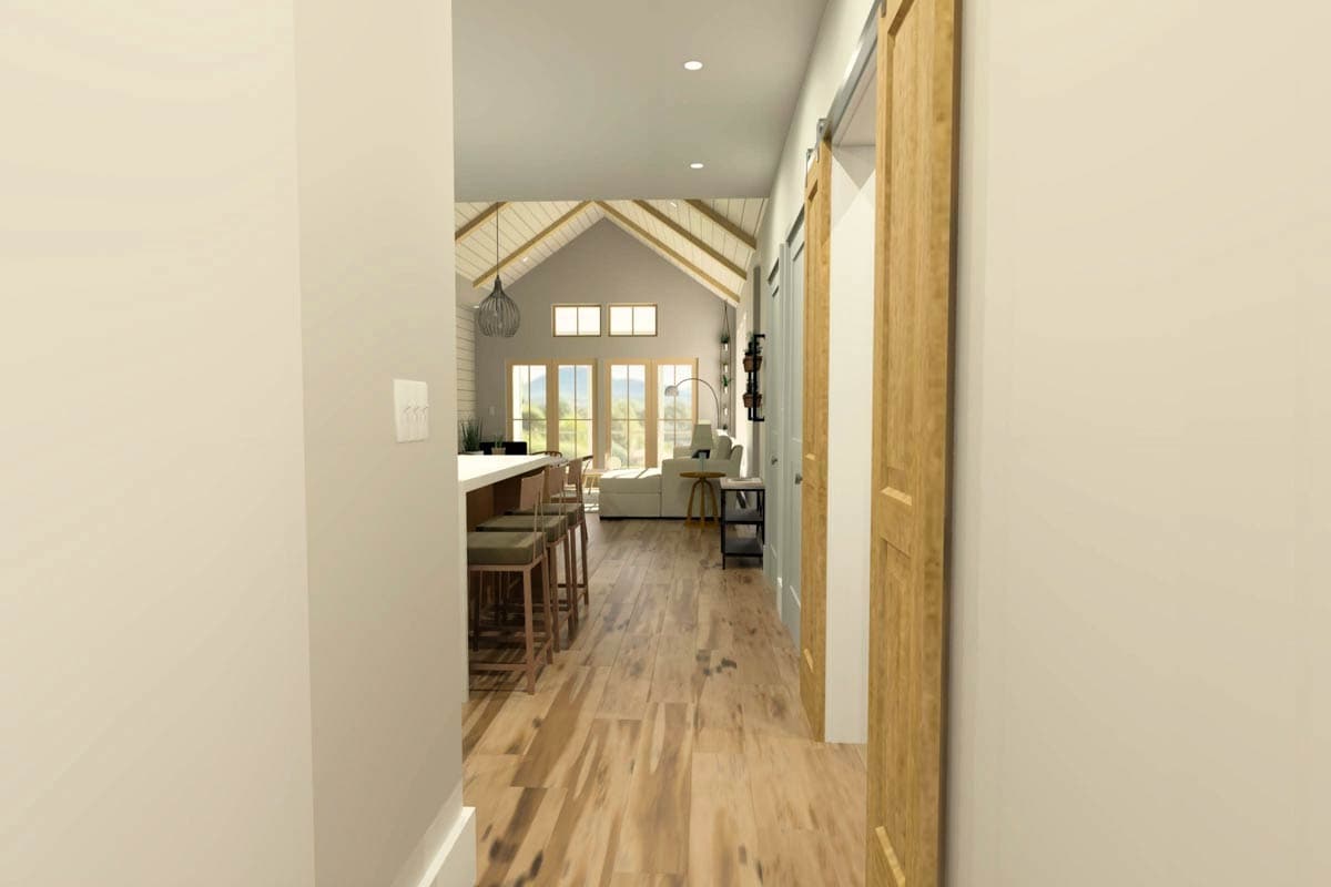 Interior rendering of a house plan showing a kitchen with island and bar stools, and a great room with vaulted ceiling and large windows.