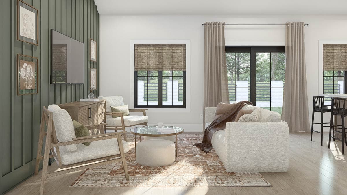 Living room with two sofas, chairs, coffee table, and patterned rug, next to a kitchen island with stools.