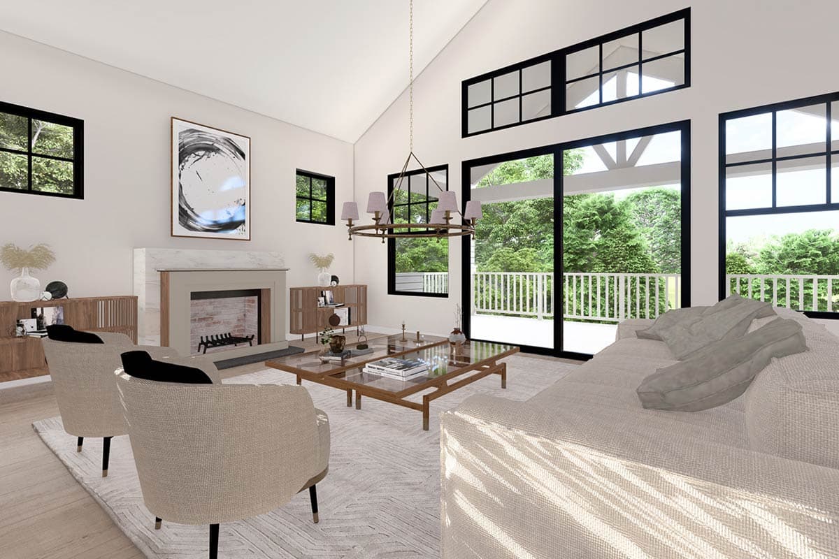 Great room interior with vaulted ceiling, stone fireplace, large windows, and sliding glass doors to a deck.