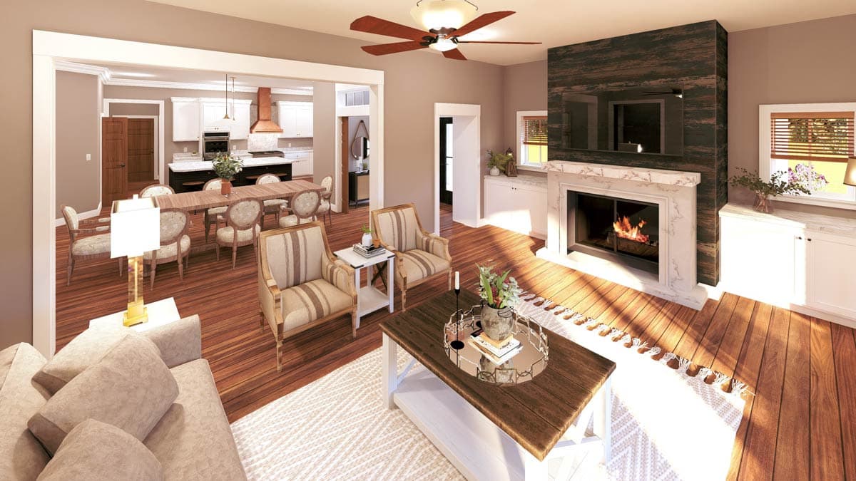 Living area with fireplace and adjacent dining room and kitchen. Wood floors throughout.