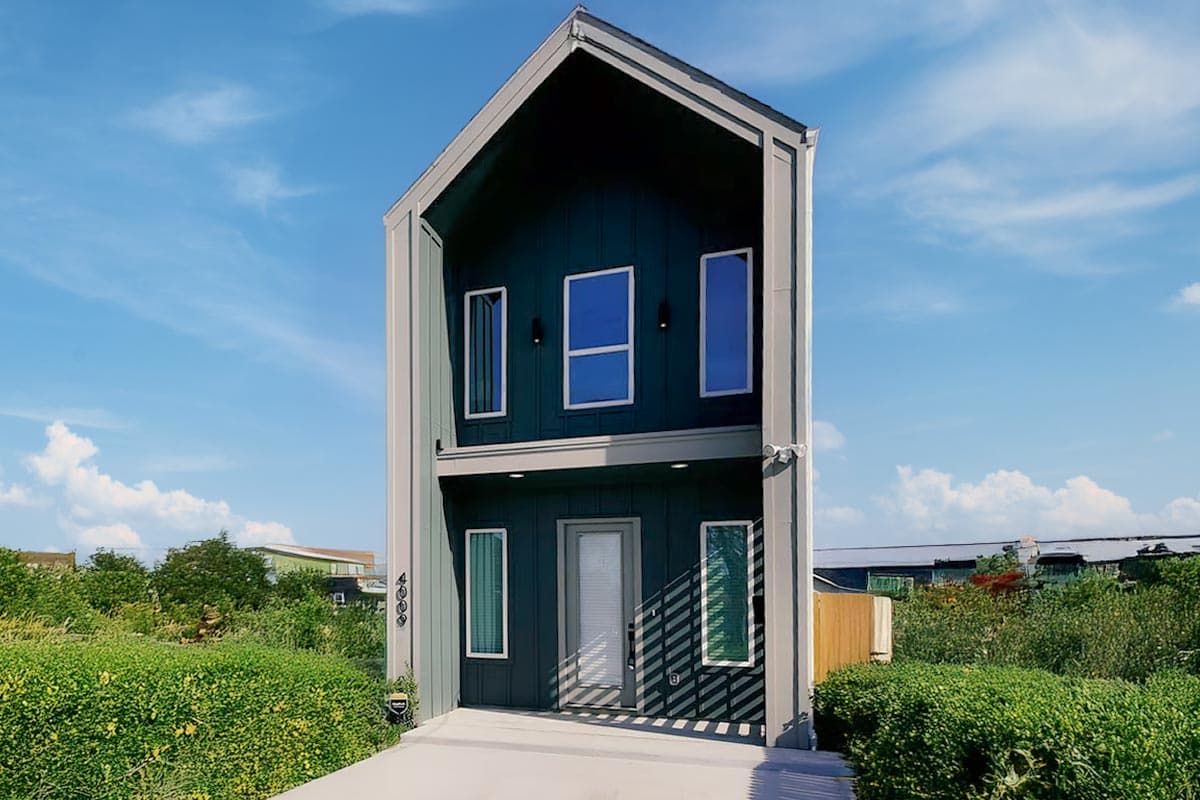 Modern two-story house plan with a steep gable roof, dark siding, and prominent vertical windows.