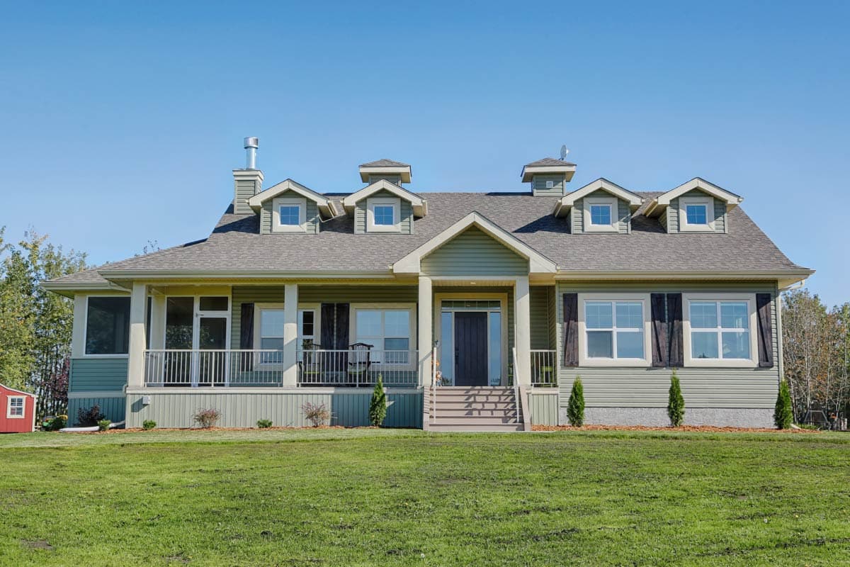 House plan exterior with dormers, a covered porch, and a hipped roof. Features a central entry with stairs and a side-entry screened porch.