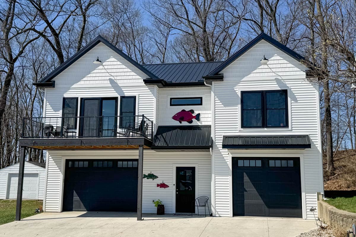 Modern Farmhouse house plan exterior with two stories, gable roofs, a second-story deck, and two garages.