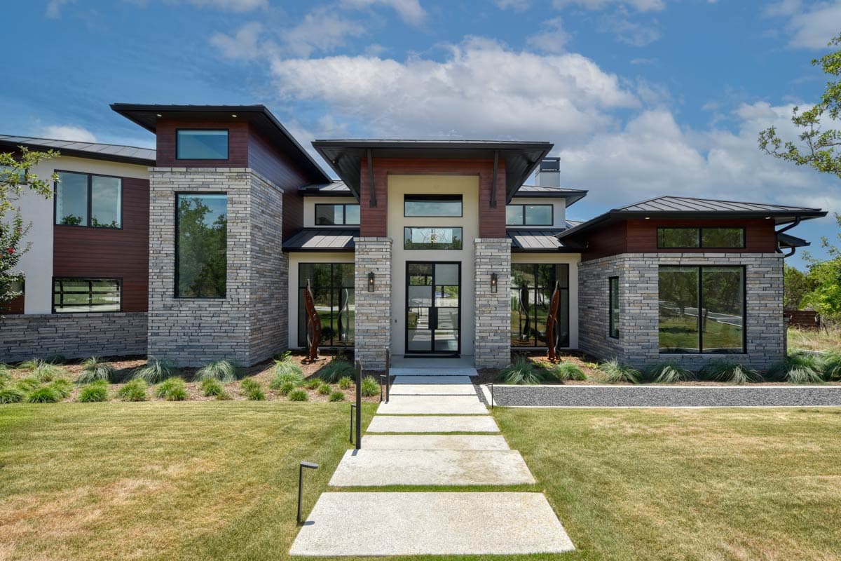 Modern house plan exterior with stone and wood siding, flat roofs, and large windows.