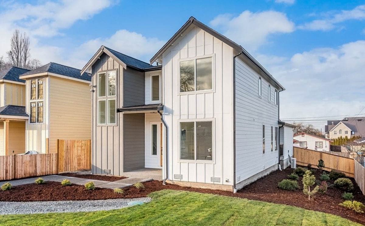 Two-story house plan exterior with vertical siding, gable rooflines, and large windows.