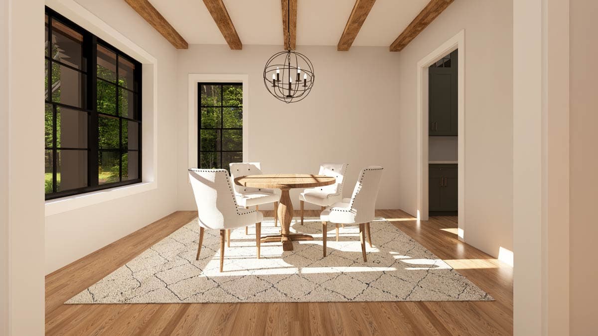 Bright dining room with a wooden table and four white chairs, light coming through windows. Decorative rug on hardwood floors.