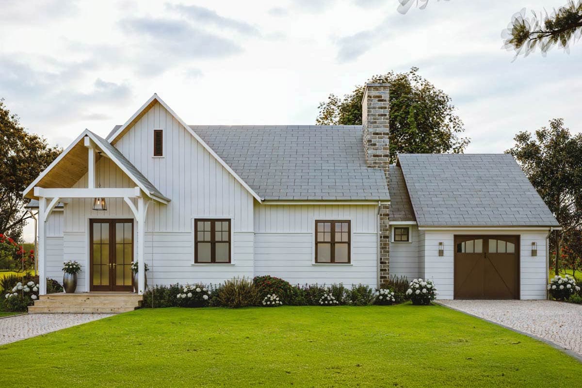House plan exterior. Two-story Modern Farmhouse with gabled roof, brick chimney, covered front porch, and attached garage.