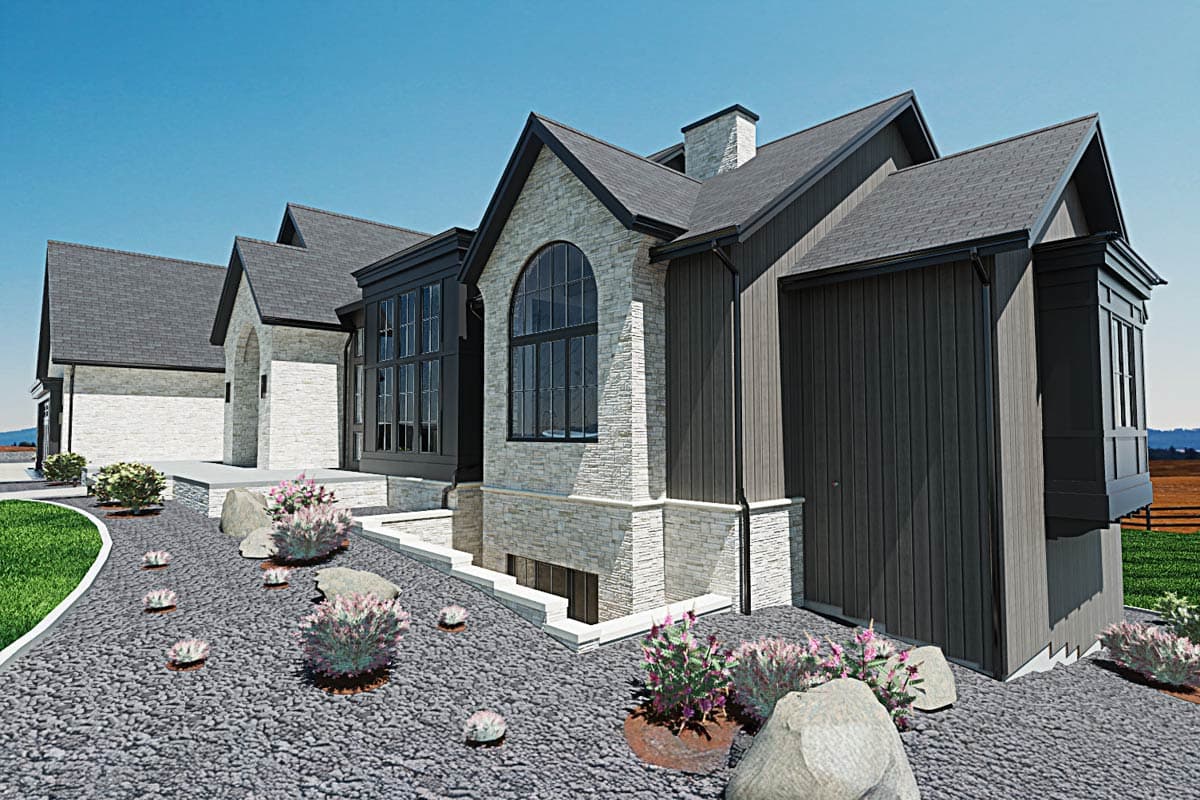 A modern, multi-gabled house with contrasting textures, including stone, dark siding, and a slate roof, set against a blue sky with landscaped gravel yard.