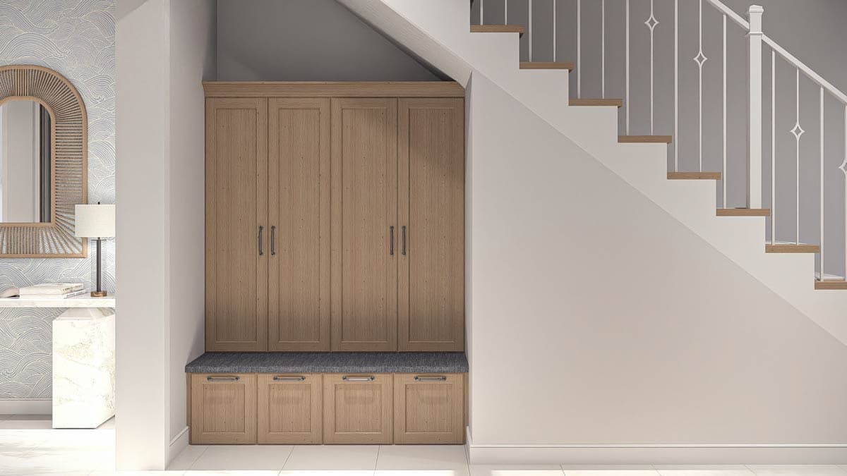Built-in wooden storage cabinets with bench seating adjacent to a staircase with white balusters.