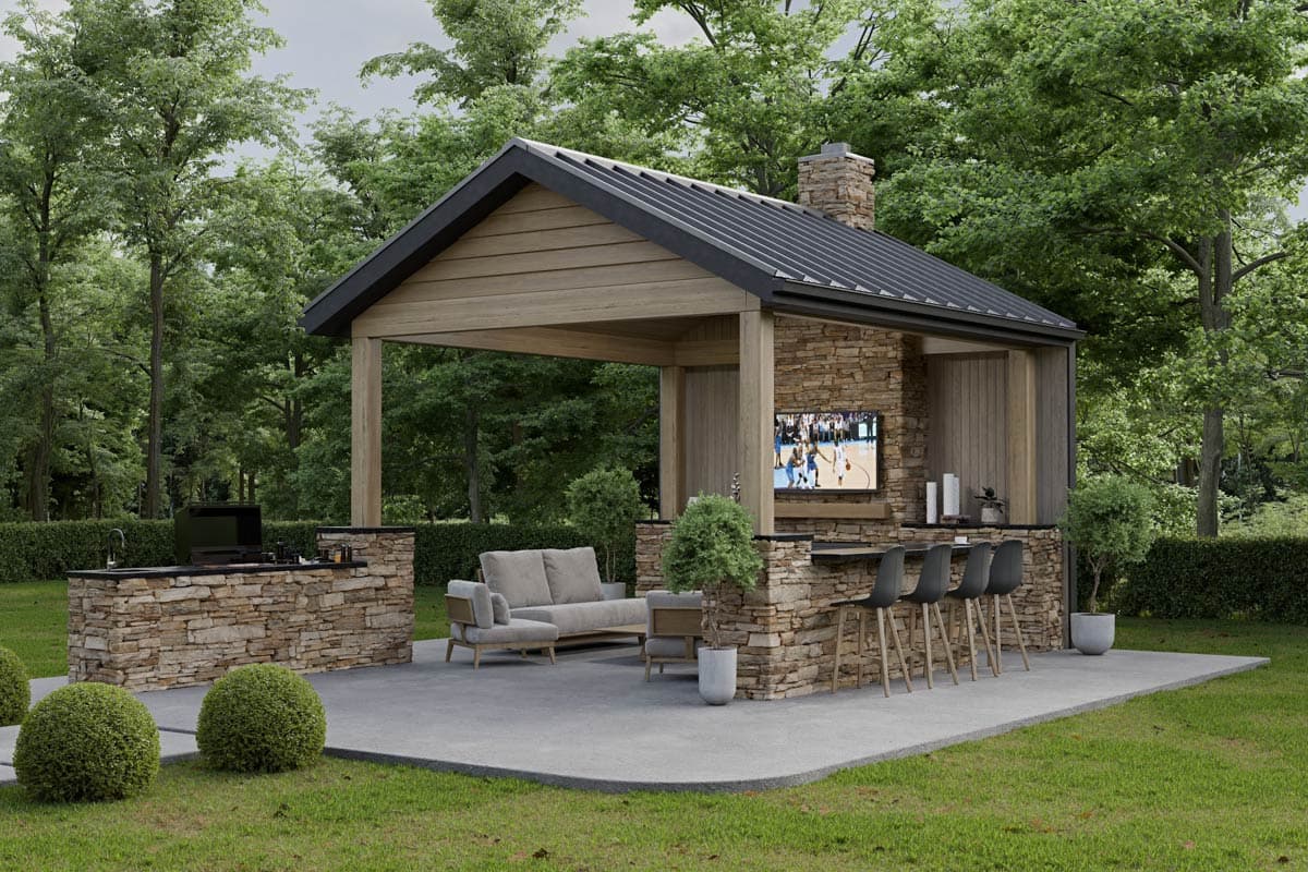 Outdoor living space with stone grill counter, covered bar seating, sofa area, and TV mounted on stone.