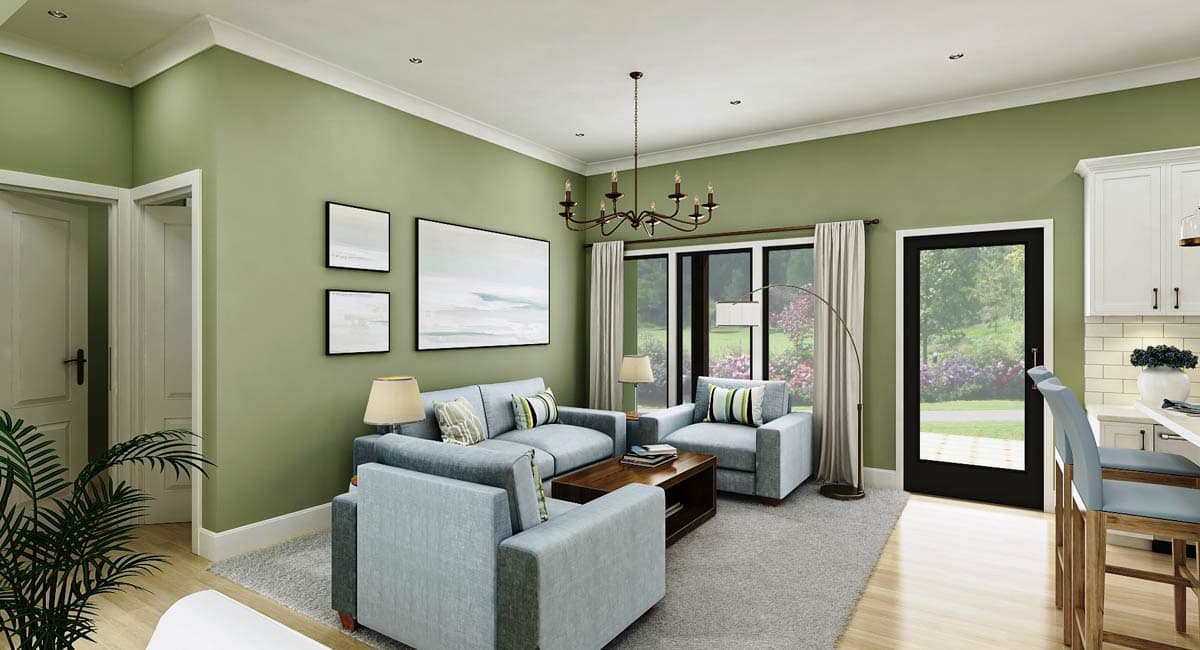 Living room with light blue sofas, coffee table, artwork, chandelier, and view to backyard through glass door.