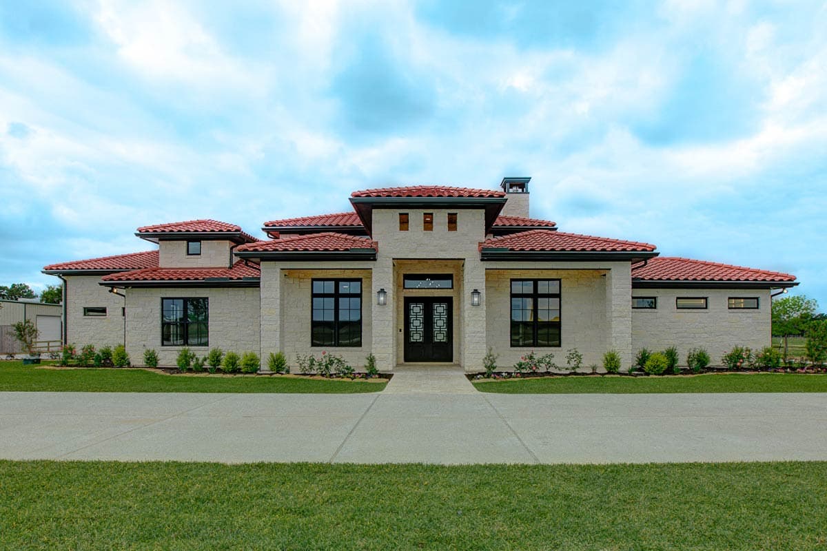 House plan exterior with Spanish style, red tile roof, and arched entryway. Features include symmetrical design, and multiple windows.