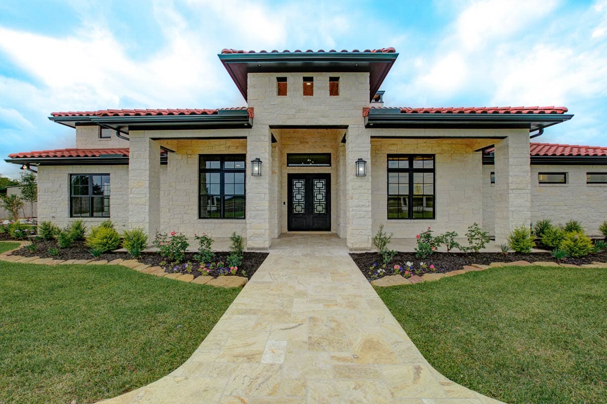 House plan exterior with a stone facade, red tile roof, prominent portico with double doors, and large windows.