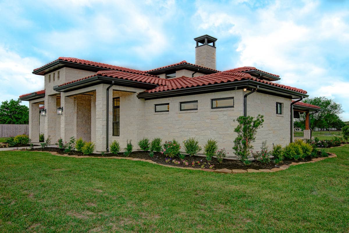 House plan exterior with stone facade, tile roof, covered entryway, and tall chimney.